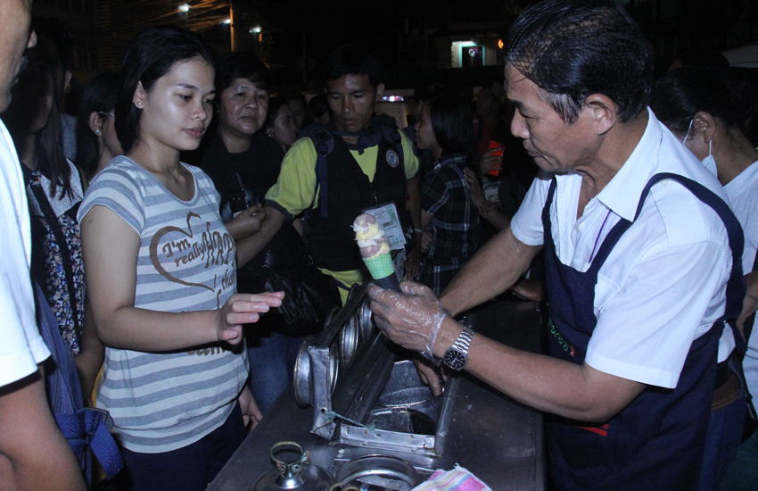 Ice-cream vendor Dionilo dela Torre, 60, is flocked by hundreds of customers along Roxas Avenue who lined up for about 3-5 hours just to buy his ice cream. Customers start to line up as early as 4:00 pm, while Dela Torre arrives at 9:00 pm. (Ace R. Morandante/davaotoday.com)