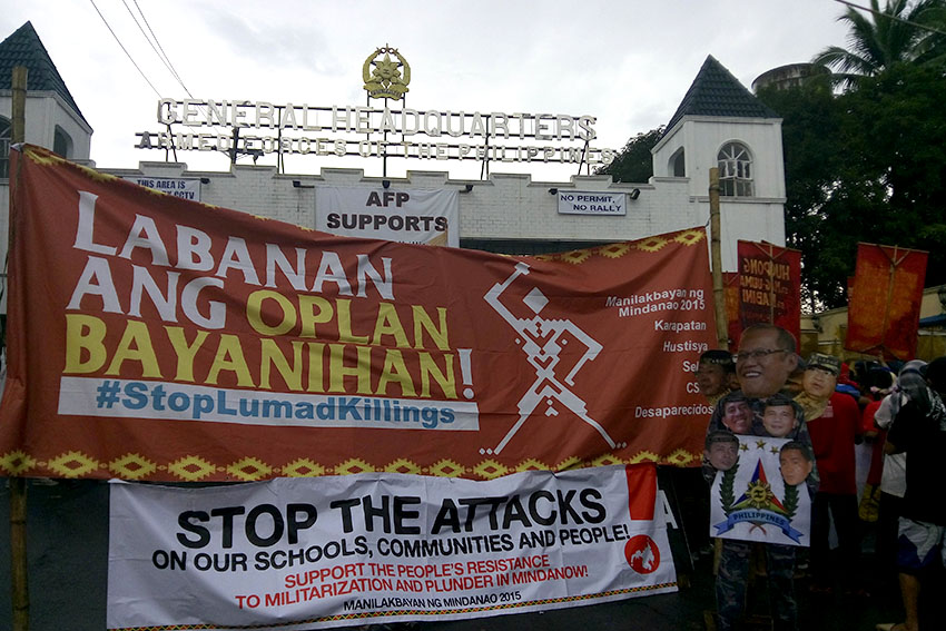 MOCKERY. Manilakbayan protesters criticize the tarpaulin displayed at the Gate 3 of Camp Aguinaldo showing their support to Stop Lumad Killings. The group said it is a mockery to the plight of Lumads as they claim that state forces are the ones heading the killings. (Earl O. Condeza/davaotoday.com)