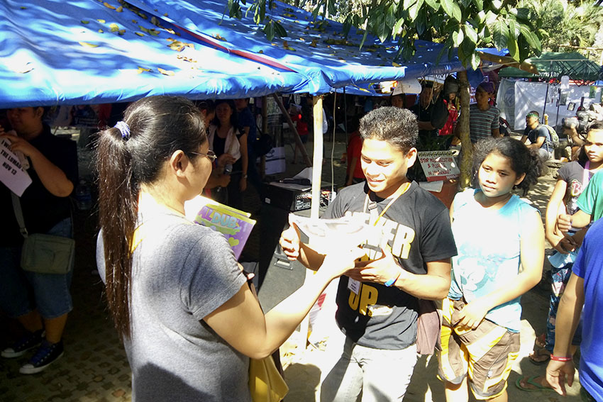 The fans' club of the dubsmash phenomenon, Aldub, a love team born out of a national TV station's segment, give coloring books to Lumad children in the camp in at Liwasang Bonifacio in Manila on Sunday morning. (Earl O. Condeza/davaotoday.com)