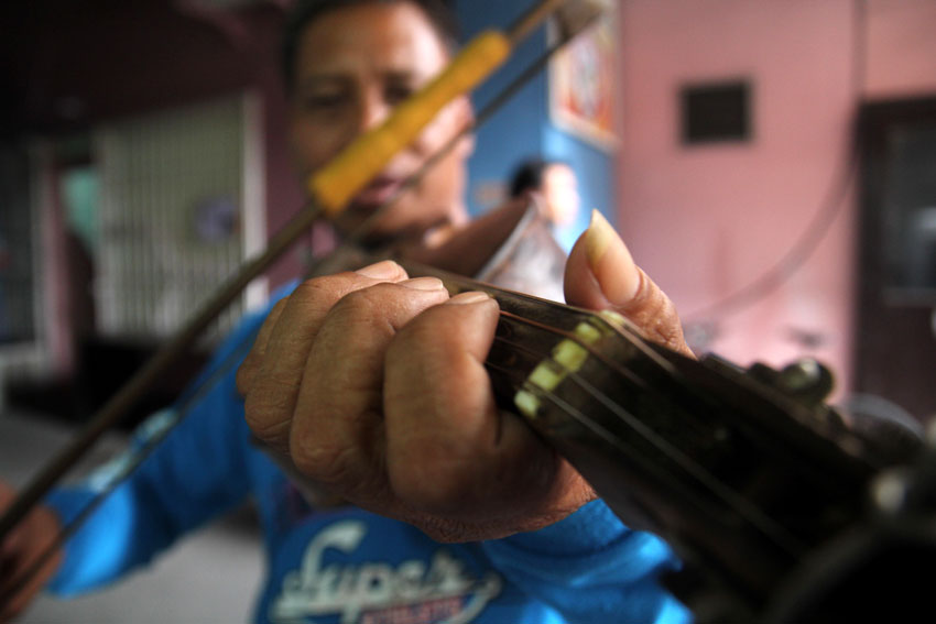 VIOLINIST. A street caroler shows his talent by using his old violin in playing Filipino Christmas songs. (Ace R. Morandante/davaotoday.com)