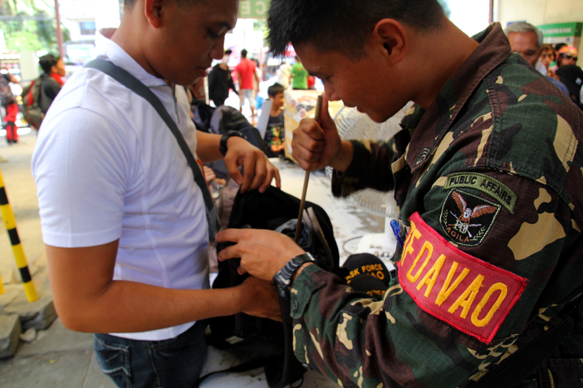 A member of the Task Force Davao inspects every individual's things for security reasons at the Davao City Overland Transport Terminal. (Ace R. Morandante/davaotoday.com)