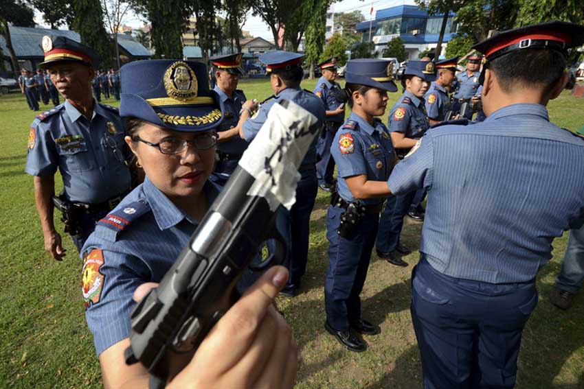 Police Senior Inspector Milgrace Driz, spokesperson of Davao City Police Office puts a tape on her pistol along with her colleagues in the entire city police command. The National Police has a policy against indiscriminate firing of their guns during Christmas Season. The muzzle-taping will end after January 1, 2016. (Ace R. Morandante/davaotoday.com)