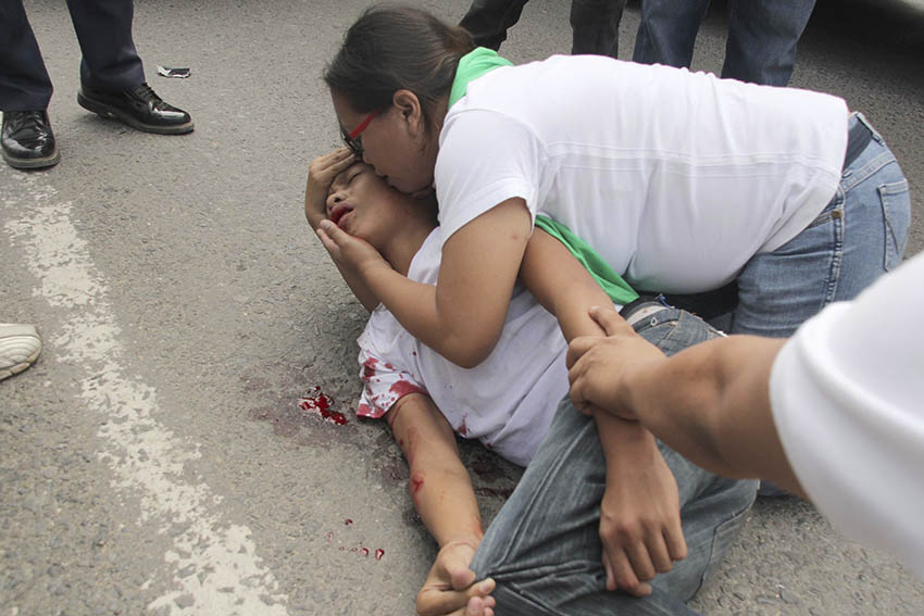 A mother attends to his son who fell unconscious after he was hit by a motorcycle along Panacan highway in Davao City Thursday afternoon.  (Medel V. Hernani/davaotoday.com)