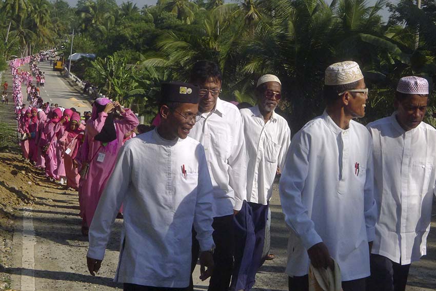 Officials, administrators, teachers and Islamic school students of Barangays Dunguan in Aleosan and Langayen in Pikit hold a parade to seal a peace pact between their two communities which have been locked in rido (clan feud) for 30 years. The Ma'ahad (Islamic High School) built at the boundary of the two communities May of this year became a marker of peace and reminder of their peace pact which they hope to be strengthened with a kanduli (feast) this Sunday. (Photo by Mohaiden Ampatuan)