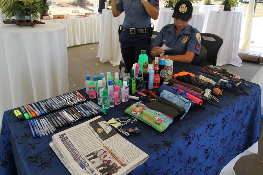 As part of their strict security measure, members of the Philippine National Police and the Presidential Security Group confiscate the personal belongings of visitors and members of the media during the inauguration of the 300-megawatt coal-fired power plant in Barangay Binugao,Toril district, Davao City on Friday. The inauguration was graced by President Benigno Aquino III and other local officials. (Ace R. Morandante/davaotoday.com)