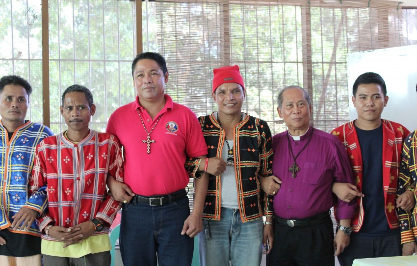 Bishop Ephraim Fajutagana (second from right), Iglesia Filipina Independiente Obispo Maximo (Supreme Bishop), and Bishop Joel Porlares (third from left), IFI bishop of Bulacan and Bataan link arms with the indigenous peoples leaders during their solidarity visit at the United Church of Christ in the Philippines Haran compound in Davao City, where hundreds of Lumads are seeking refuge since March, last year. Fajutagana said the root cause of the conflict is the big foreign mining investors and their local Filipino counterpart who wish to extract the resources of the Lumads ancestral lands.(Medel V. Hernani/davaotoday.com)