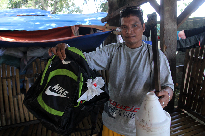 Datu Mintroso Malibato, chairperson of Karadyawan, a lumad organization from Kapalong, Davao del Norte shows a backpack with 1.5 liters of gasoline that was seen at the back of the burned student dormitory. (Photo by Ace Morandante/davaotoday.com)