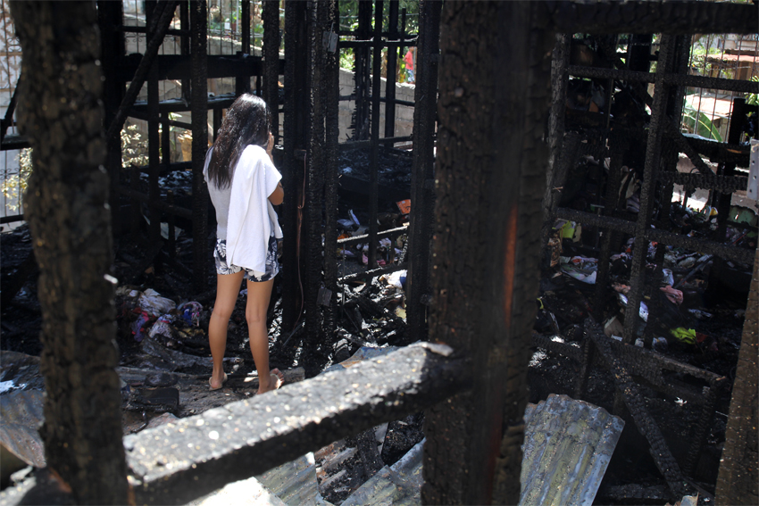 Rainbe Bartolome, a 17-year-old college student, stares at the remains of her dormitory. A new boarder, she says all her possessions, including her books, were burned. (Photo by Ace Morandante/davaotoday.com)