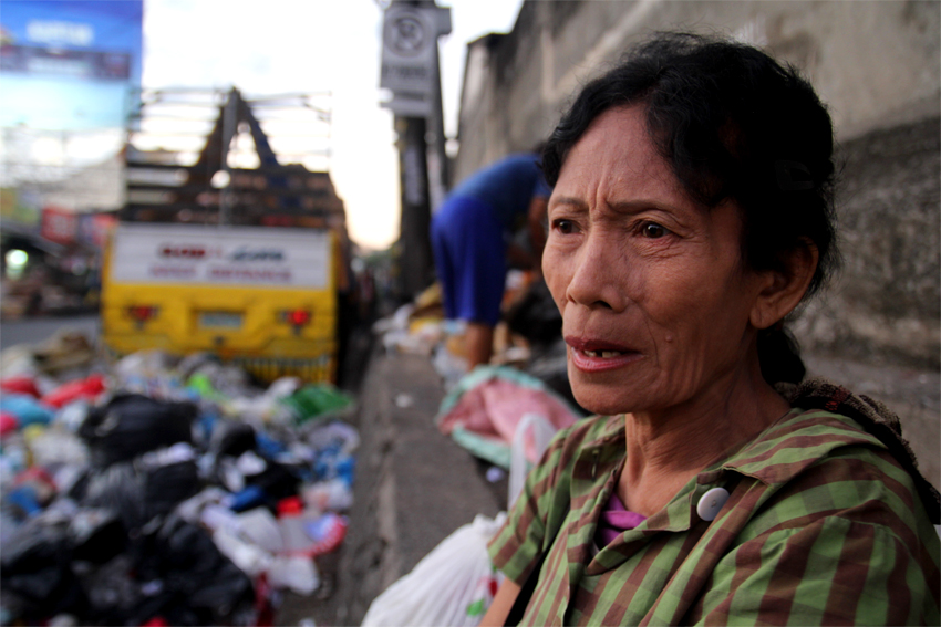 CASH-TRAPPED. Jolita Ladica, 58, is a street sweeper who feeds her children with trashed food from the market. Her salary is used to pay for debts. (Ace R. Morandante/davaotoday.com)