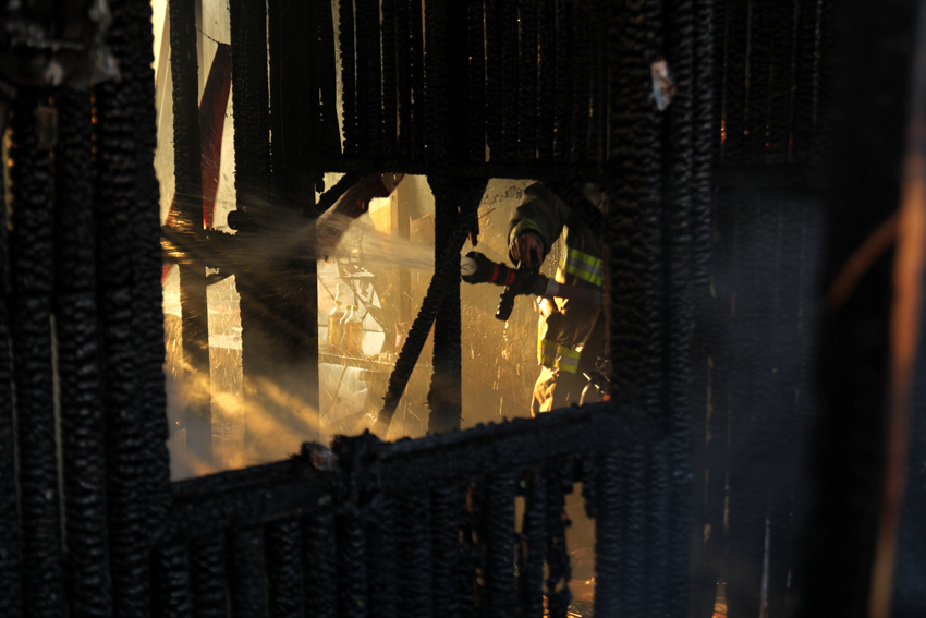 FIRE FIGHTING. A fire fighter puts out a fire affecting around 50 houses in Bucana, Barangay 76-A on Tuesday, March 8. (Ace R. Morandante/davaotoday.com)