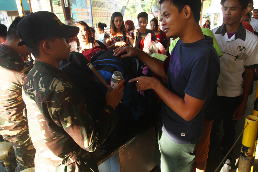 TERMINAL. A commuter is reprimanded by an officer of the Task Force Davao after being caught bringing a bottle of butane gas during the inspection at the entrance of Davao City Overland Transport Terminal in Ecoland. (Ace R. Morandante/davaotoday.com)