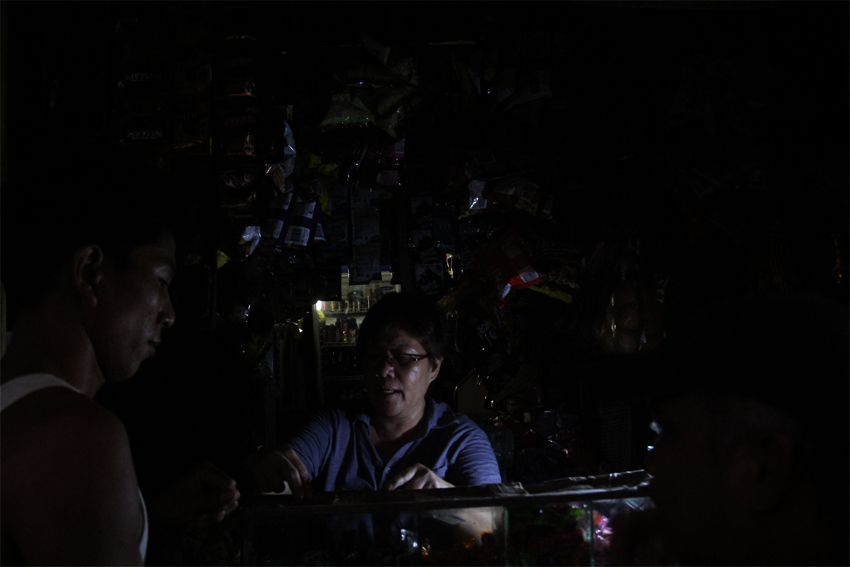 With the help of flashlights, it's business as usual for store owner Leo Garcia amid the recurring outages in Davao City. (Ace R. Morandante/davaotoday.com)