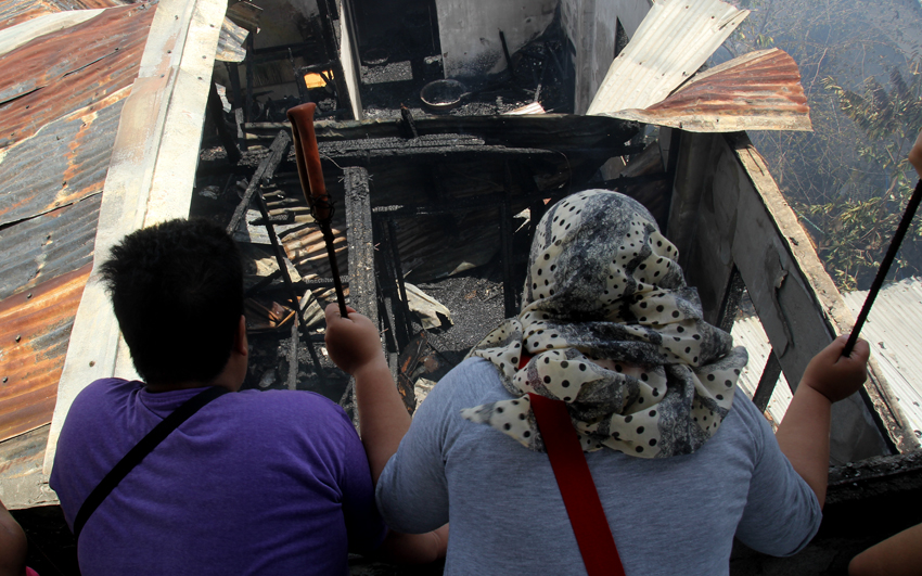 A house owner looks at where their house once stood. She said they only managed to save a few important documents.(Ace R. Morandante/davaotoday.com)