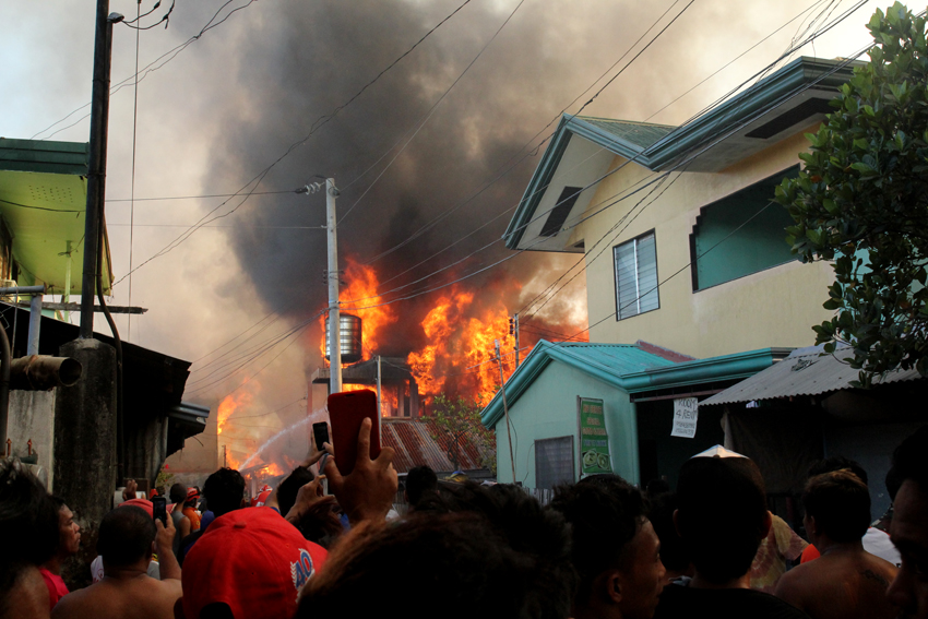 Pedicab drivers and bystanders taking videos and photos of the fire incident in Barangay 76-A Bucana, Davao City on Tuesday are seen blocking the narrow road where fire trucks need to pass. (Ace R. Morandante/davaotoday.com)