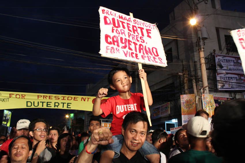 This father and son pose for the camera while waiting for Mayor Rodrigo Duterte and his the running Peter Cayetano for Vice President on stage.(Medel V. Hernani/davaotoday.com)