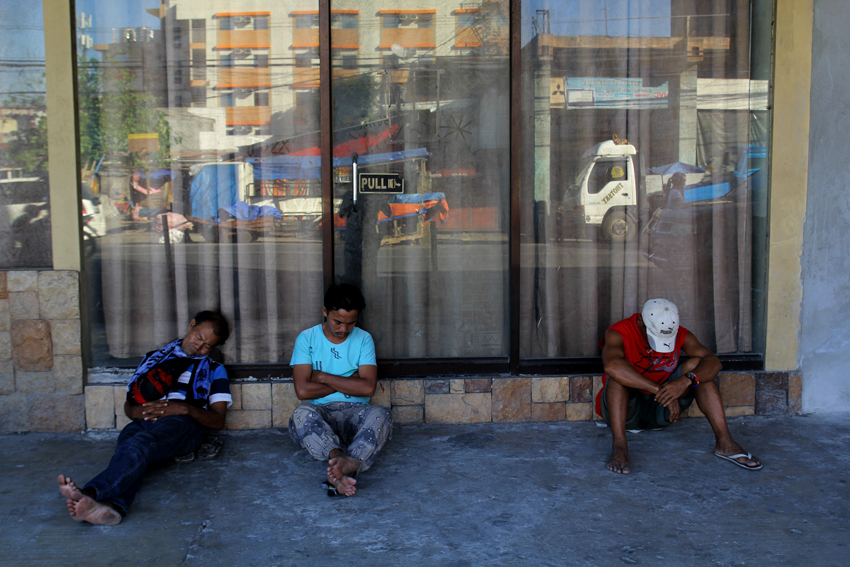 Three porters at the Bankerohan Public Market take their siesta while waiting for the hundreds of kilos of vegetables from Marilog District to come. (Ace R.Morandante/davaotoday.com)