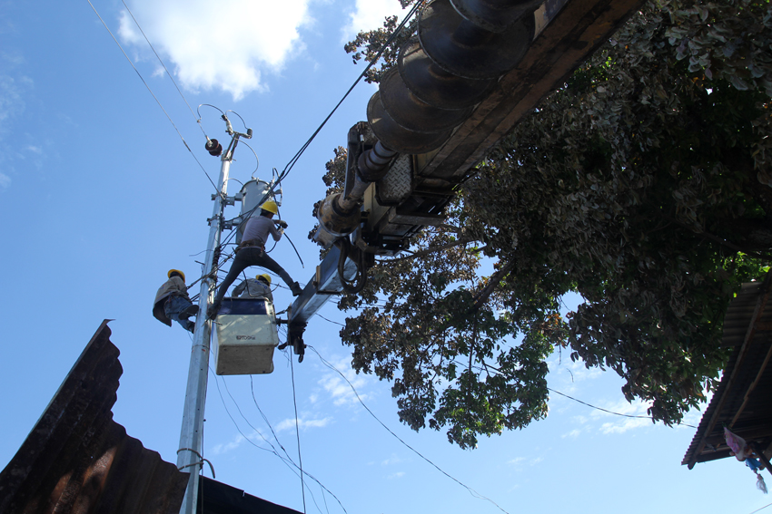 Workers of Davao Light & Power Company install a new post in a village affected by fire in Barangay 5-A, Davao City. (Ace R. Morandante/davaotoday.com) 