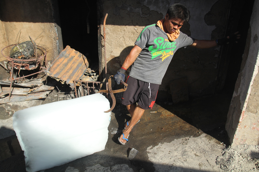 A worker pulls a block of ice inside their storage room in Bankerohan which was affected by fire last Friday, April 15. (Ace R. Morandante/davaotoday.com)