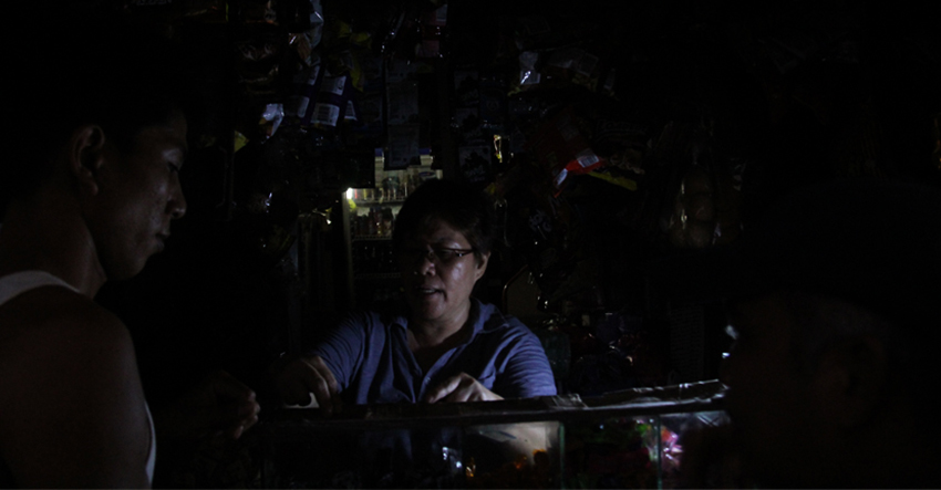 With the help of flashlights, it's business as usual for store owner Leo Garcia amid the recurring outages in Davao City. (Ace R. Morandante/davaotoday.com file photo)