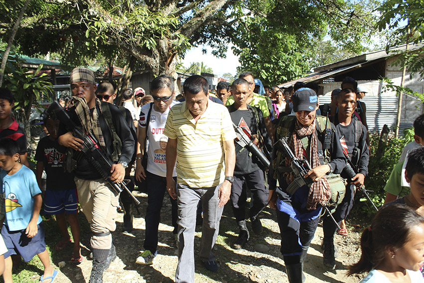 ESCORT. Members of the NPA escorted Duterte as he walks toward the gymnasium in Barangay Lumiad, Paquibato. (Earl O. Condeza/davaotoday.com)