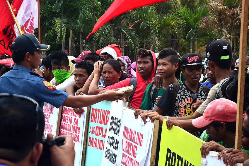 OFFER. Amid the tension, a policemen tries to offer a pack snacks to some protesters.(Earl O. Condeza)