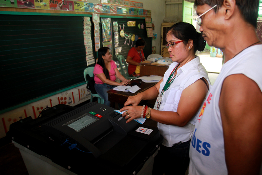 Board of Election Inspector Fe Agusto cut the voter's election receipt during the final testing and sealing of the counting machines at the Buhangin Elementary School in Davao City, Thursday morning. (Ace R. Morandante/davaotoday.com)