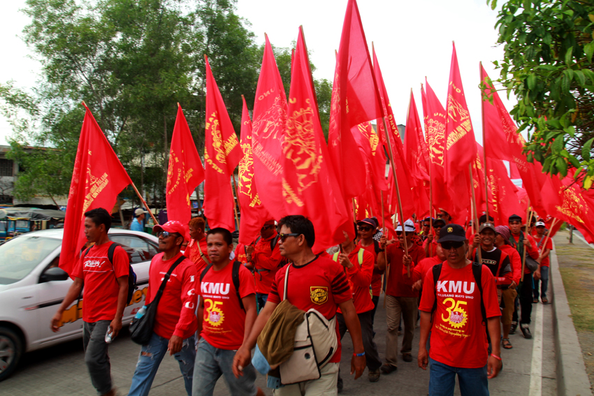 Union members affiliated to the labor center, Kilusang Mayo Uno raise the red flags while they march the streets from Magsaysay Park to Rizal Park.