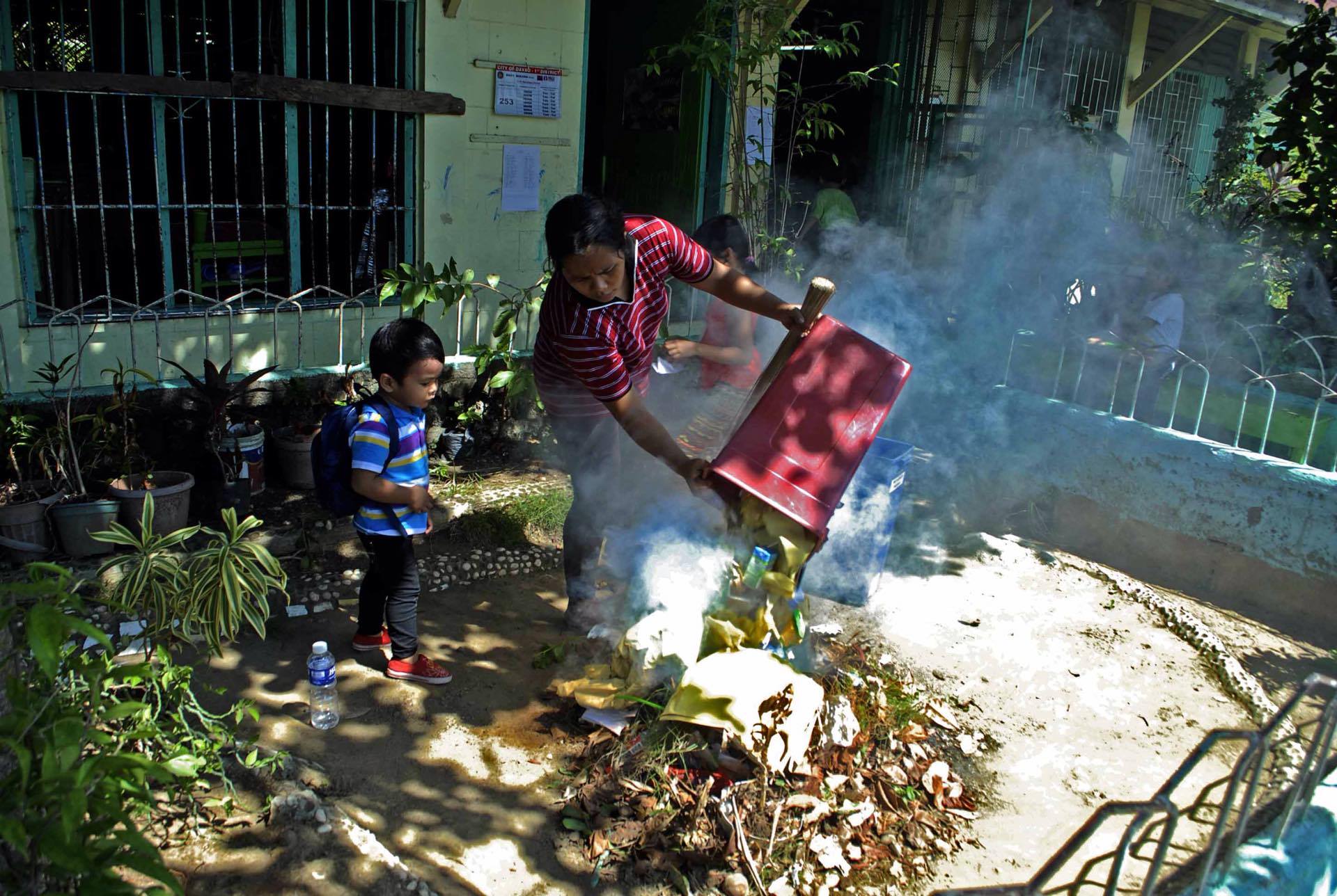 Volunteers of the annual Brigada Eskwela, a clean up and school maintenance program of the Education Department, burn trash as they clean the school premises inside SIR Elementary School in Davao City. However, environment watchdog has warned of burning trash as this may discharge toxins that can trigger illnesses. (Ace R. Morandante/davaotoday.com)