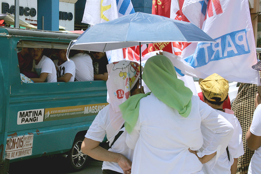 Commuters and passersby along San Pedro street give their short time looking and listening to protesters who accuse the current administration of alleged electoral fraud. (Earl O. Condeza/davaotoday.com)