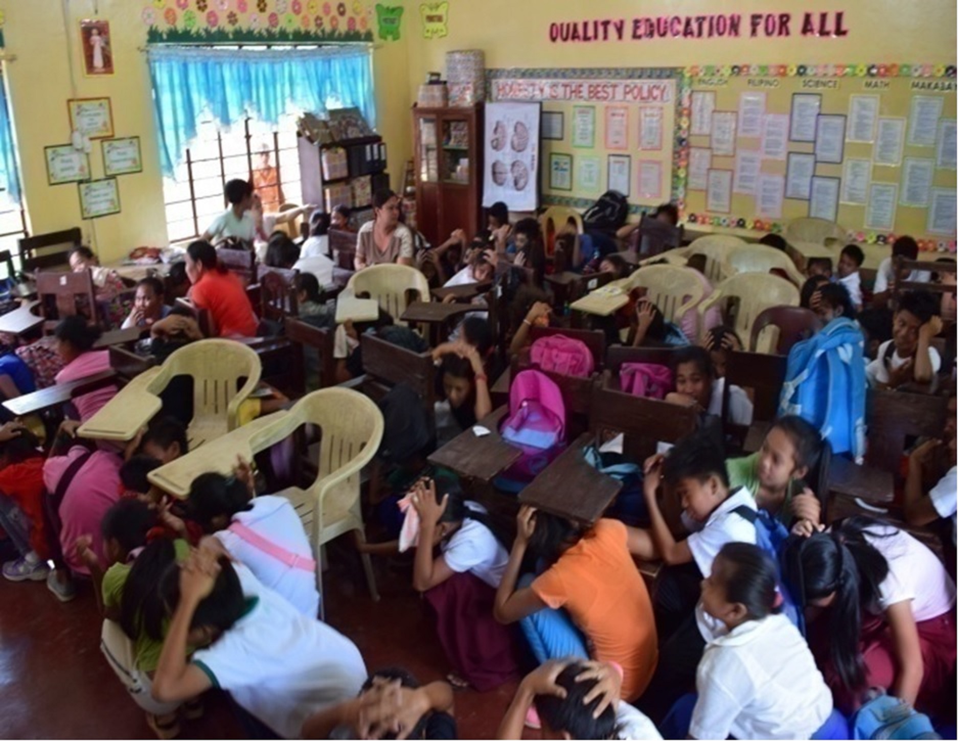 QUAKE DRILL. Students perform the earthquake drill in one of the Oplan ANDAM caravans. (Photo courtesy of Davao del Norte PDRRM.)
