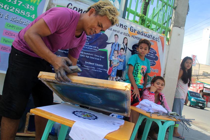 PRINTING BUSINESS.Mark Mangubat, 35, prints school logo on shirts in front of Kapitan Tomas Senior Central Elementary School in Ponciano Street. in Davao City.   (Ace R. Morandante/davaotoday.com)