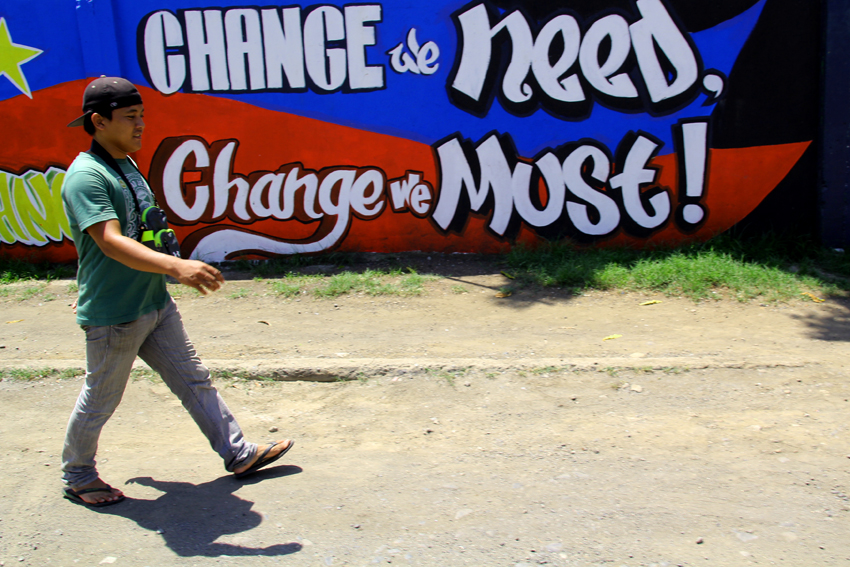 CHANGE WE NEED. A man walks in an alley in Matina, Davao City where an artwork inspired by the motto of President-elect Rodrigo Duterte's campaign is painted.(Ace R.Morandante/davaotoday.com)