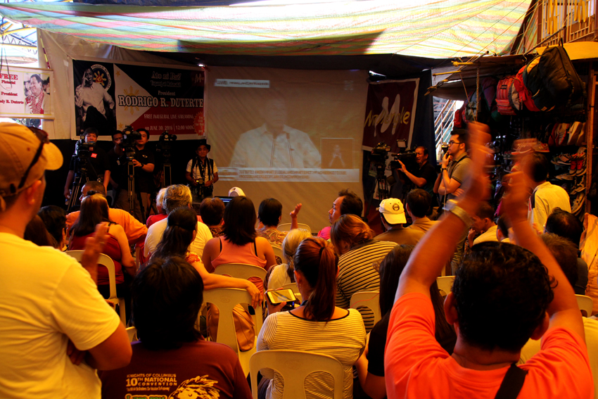 Davaoeños cheer and applaud President Rodrigo Duterte as they watch him deliver his inaugural speech through a big screen monitor inside the Mallengke in Bankerohan Public Market in Davao City on Thursday, June 30.(Ace R.Morandante/davaotoday.com)