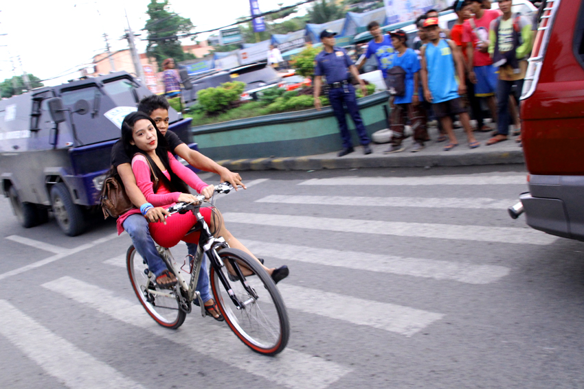 A couple rides in a bike without any protection along Quimpo Boulevard in Davao City. (Ace R. Morandante/davaotoday.com)