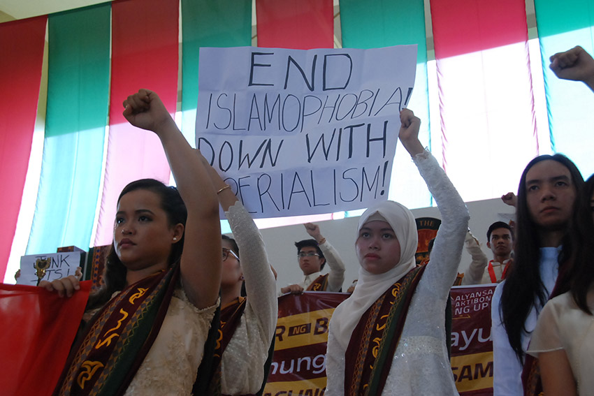 GRADUATES. Moro graduates of the University of the Philippines Mindanao hold a placard during a lightning rally held at the commencement ceremony on Tuesday, June 28. (Isaiah Shallom Baluso/Contributor)