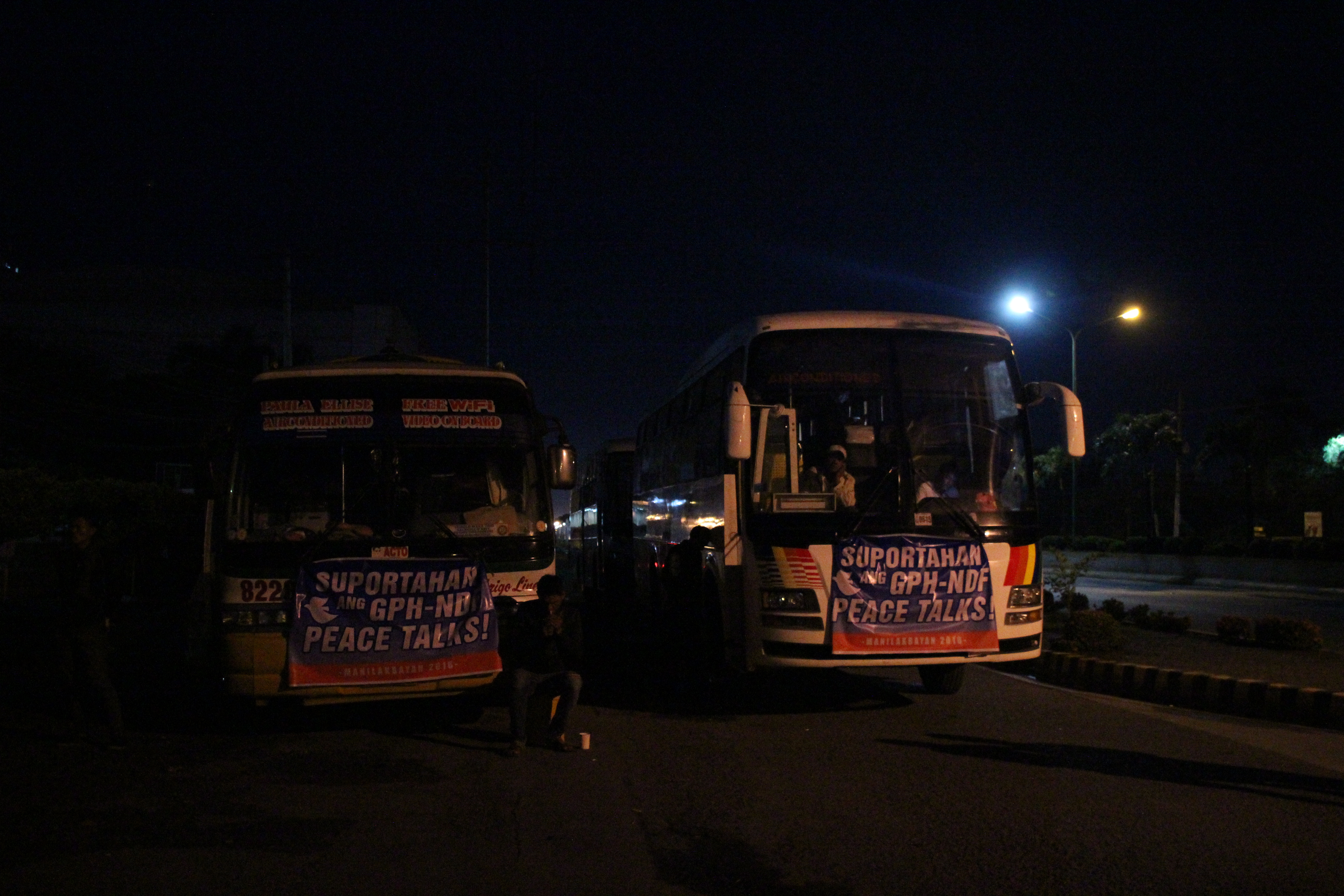 Several buses which will ferry the delegates from Tagum City to Manila are parked outside the United Church of Christ in the Philippines compound on Monday night.  Tarpaulins calling for the resumption of peace talks between the government and the National Democratic Front of the Philippines hang outside the buses.