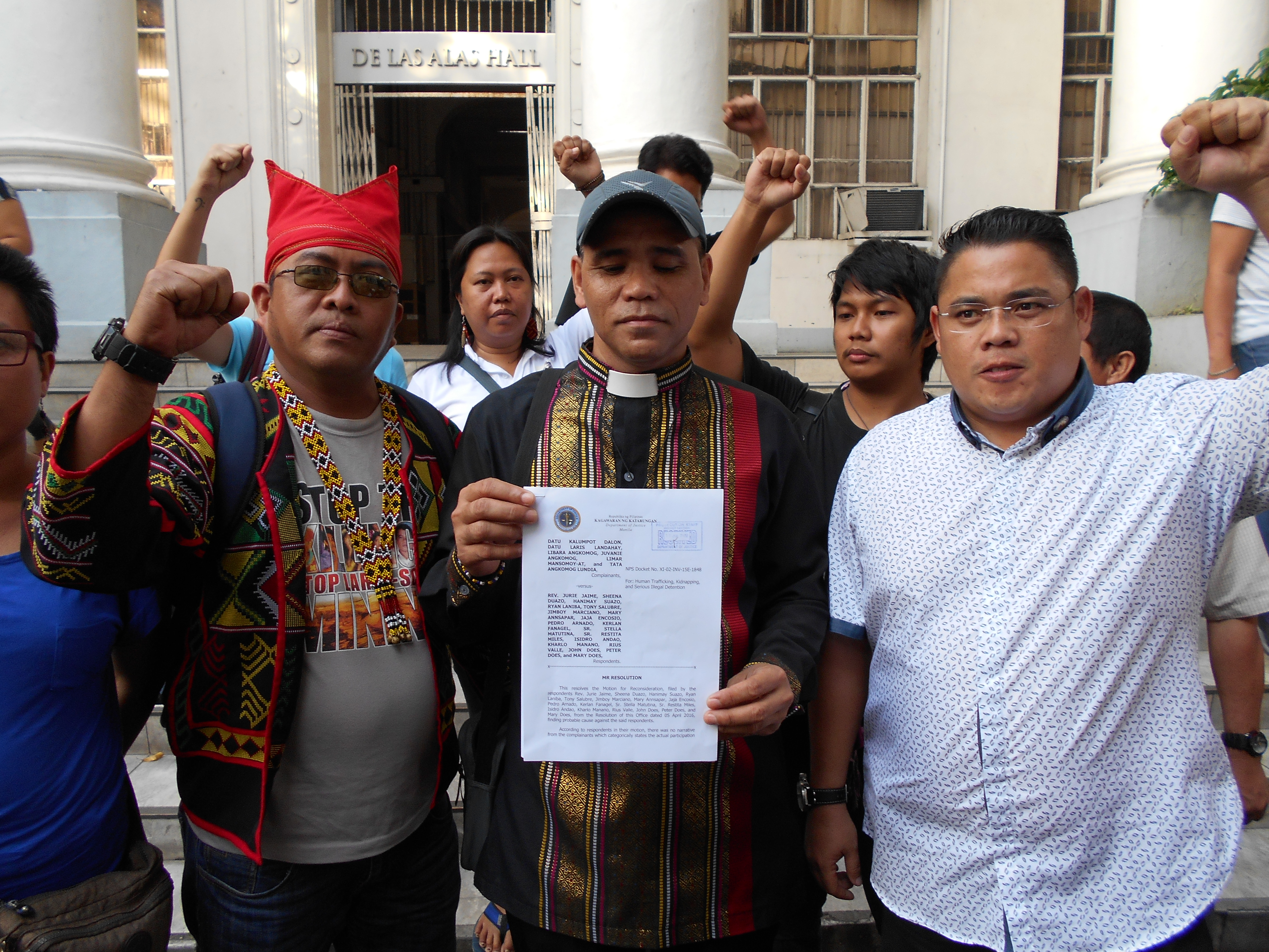 CASE DISMISSED. Activists who were accused of kidnapping indigenous people evacuees in Davao City are elated with the decision of the Department of Justice to dismiss their case on Monday afternoon at the DOJ office in Manila. Reverend Jurie Jaime, convenor of the Exodus for Justice and Peace, holds the copy of the DOJ resolution. He is flanked by Kerlan Fanagel, chairperson of the Pasaka Confederation of Lumad Organizations in Southern Mindanao (on the left) and Anakpawis Partylist Rep. Ariel Casilao. Mary Ann Sapar of Gabriela and Rius Valle of Children's Rehabilitation Center are at the back. (Contributed photo)