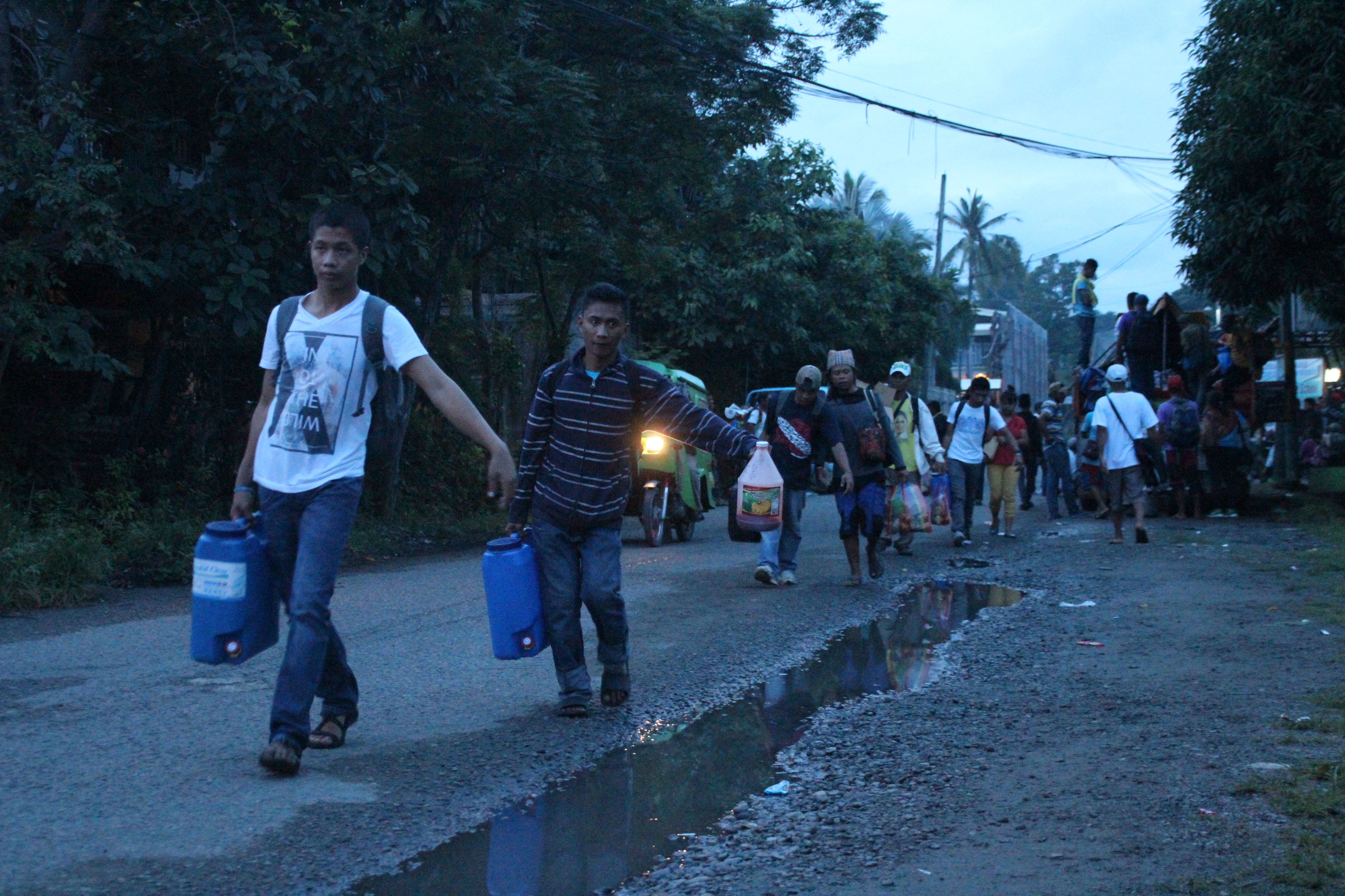 Some delegates of the Manilakbayan sa SONA caravan carry their supplies from the UCCP compound to their buses.