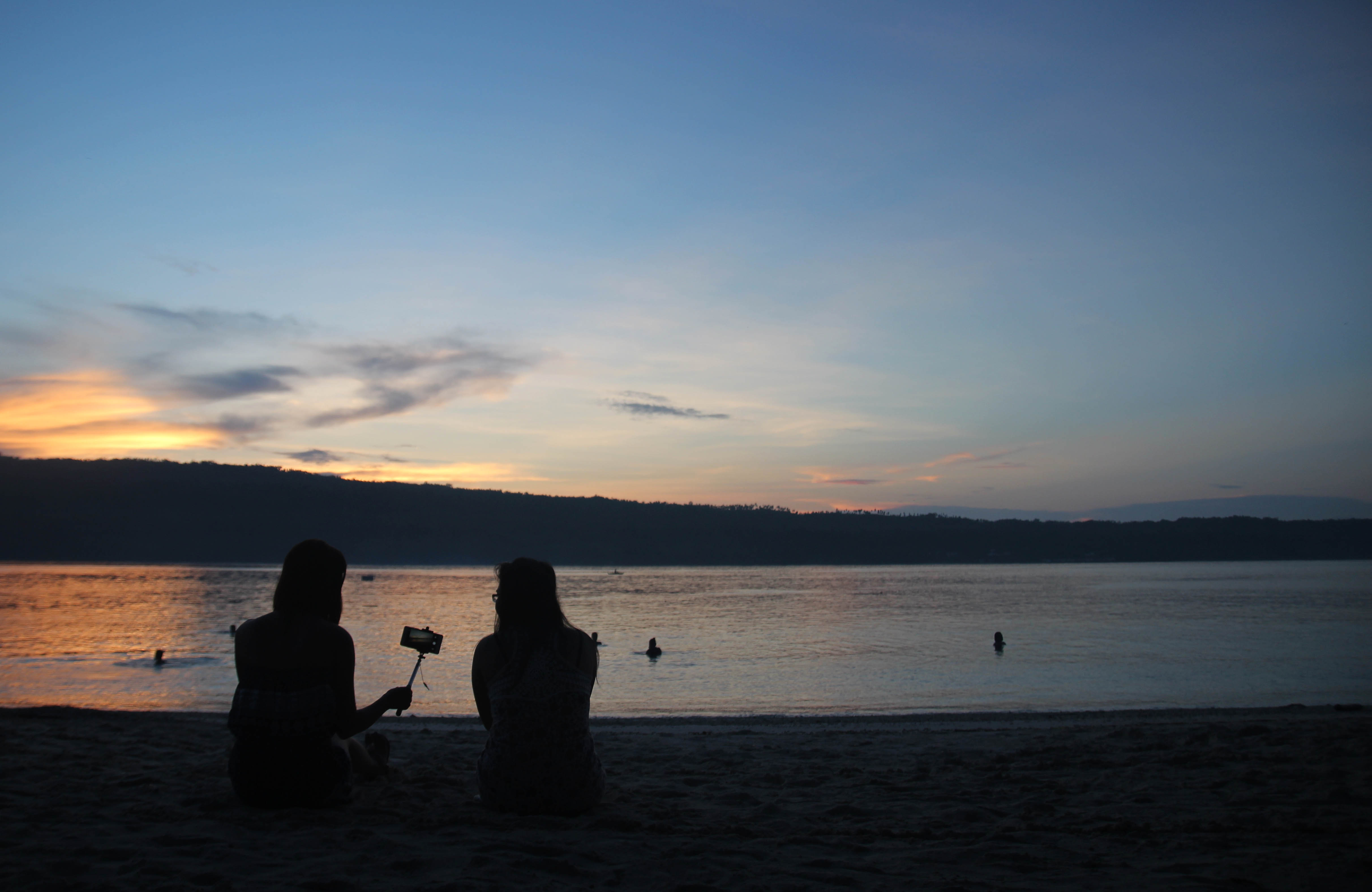 WAITING FOR SUNRISE. As early as 5:00 am, these two young ladies sit on the sand with a camera to wait for sunrise at the Isla Reta beach resort in the Island Garden City of Samal. (Medel V. Hernani/davaotoday.com)