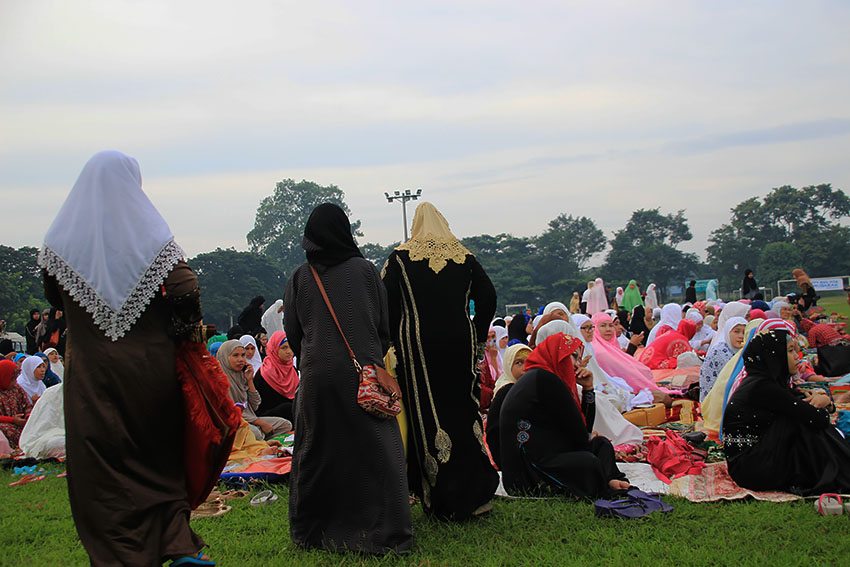  Ranging from the plain simple to the elaborate, Muslim women don their hijab as they join the gathering. They find their places separate from the men at the back of the large group.