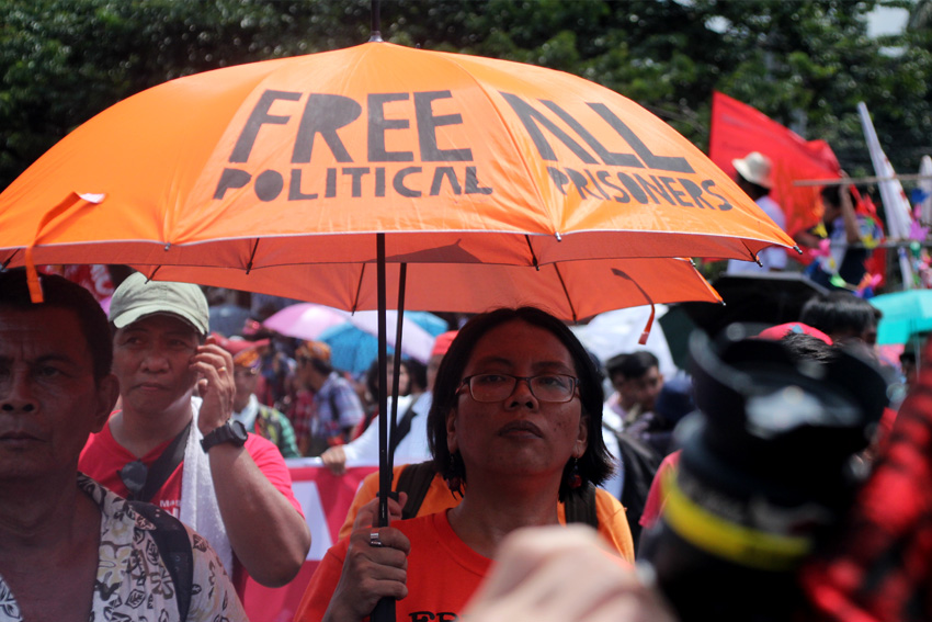 Christina Palabay, spokesperson of human rights group Karapatan, bring an umbrella with their call to free all political prisoners.