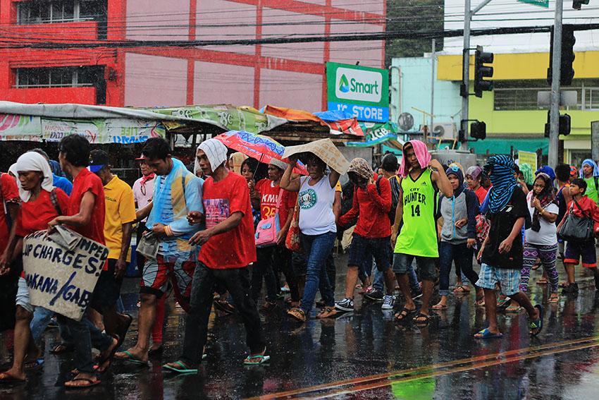 RAIN OR SHINE. Hours before President Rodrigo Duterte's first State of the Nation Address, hundreds of Davaoeños brave the rains marching from Roxas Avenue to Rizal Park in San Pedro Street where they will hold their program dubbed "SONA ng Bayan". 
