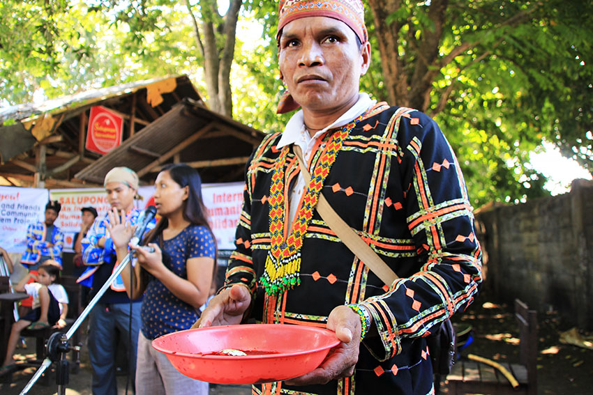 Datu Mentroso Malibato holds a plate containing the blood of a chicken that was earlier sacrificed in a ritual called the pamaas to ask for the safety of the delegates of the Salupongan: An International Humanitarian and Solidarity Mission. Some 30 activists from Europe, Latin America, USA, Hong Kong will be immersing with the different Lumad communities in Mindanao from July 16 to 21. (Paulo C. Rizal/davaotoday.com)