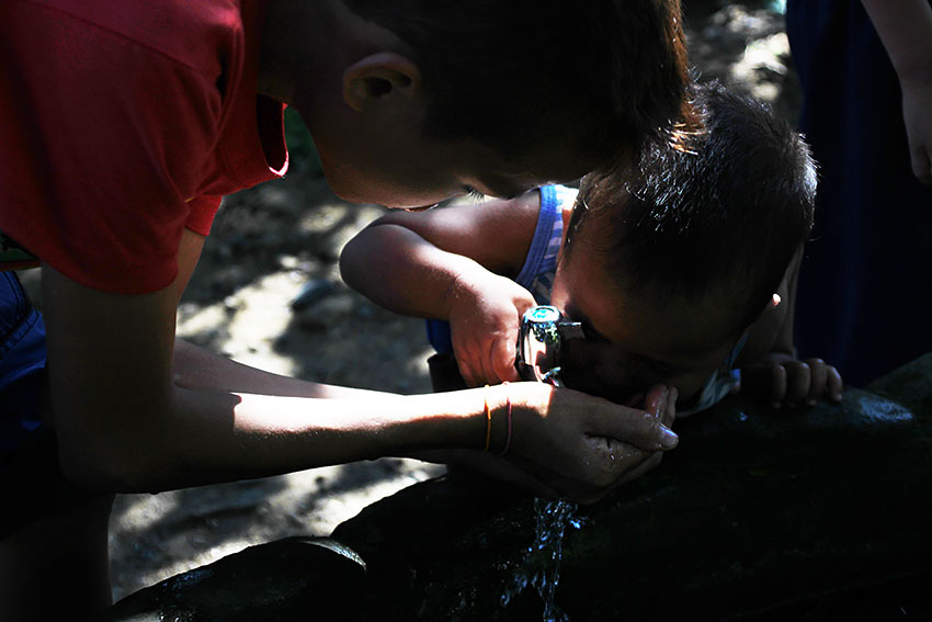 A young child drinks from the cupped hand of an older playmate inside the UCCP Haran compound in Fr. Selga Street, Davao City.  (Paulo C. Rizal/davaotoday.com)