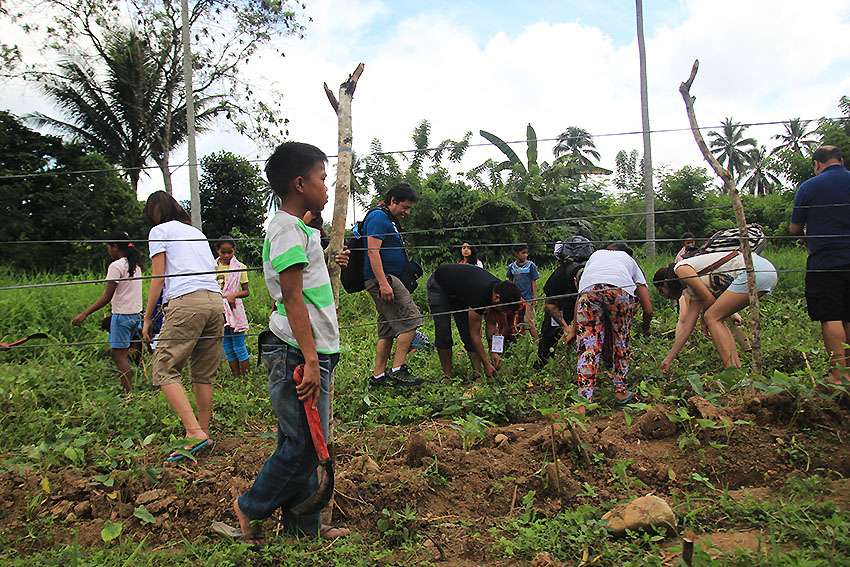 STUDENT FARMER. A young student holds his bolo while watching the foreign delegates of the International Solidarity Mission help clear out the weeds in their vegetable garden at the Mindanao Interfaith Services Foundation Incorporated (MISFI) school in Kisante, Makilala, North Cotabato.  (Paulo C. Rizal/davaotoday.com)