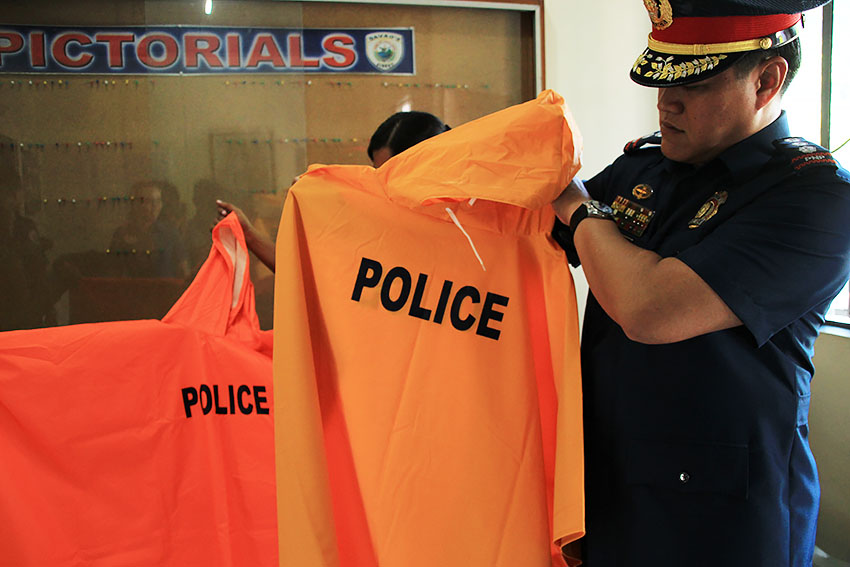 Anticipating more rains now that the country is in the La Niña season, Davao City Police Chief Michael John Dubria inspects the quality of a raincoat from a prospective supplier. (Paulo C. Rizal/davaotoday.com)