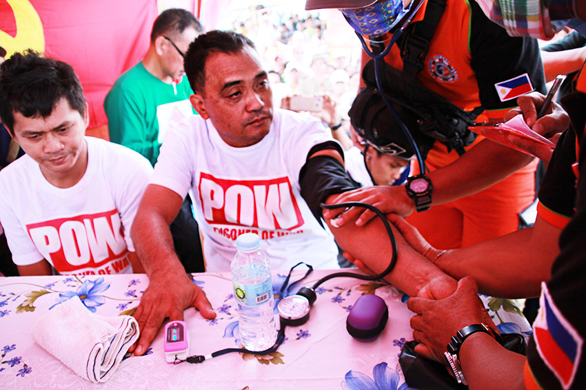 Medical personnel from Surigao City local government check the vital signs of Rodrigo Angob (center), a non-uniformed personnel and Police Officer 2 Caleb Sinaca (left) of the Malimono Municipal Police Station before they were released by the New People's Army. They were among the four prisoners of war released by the NPA on Saturday afternoon, August 27 in Barangay Mat-i, Surigao City (Paulo C. Rizal/davaotoday.com)