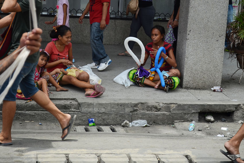 SAMA BADJAO WOMEN. Sama Badjao women with their children sit along C.M. Recto street in Davao City to ask for alms from passersby during the floral float parade  on Sunday, August 21, 2016. The Sama Badjao is one of the 11 tribes in the city for whom the Kadayawan celebration is dedicated, however, their plight has yet to be addressed by the government.