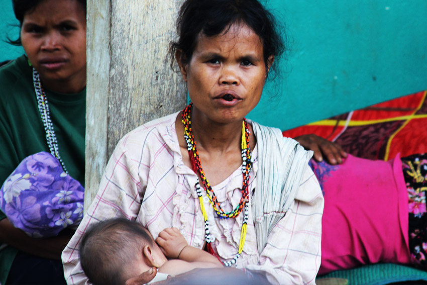   A Tigwahanon mother nurses her child outside the multi-purpose hall in Barangay Kawayan, San Fernando Bukidnon on Sunday, July 31. She is among the survivors of the strafing incident led by an alleged member of a militia group in Sitio Tibugawan, Barangay Kawayan on Saturday morning, July 30. A nine-month old pregant woman died in the firing. (Earl O. Condeza/davaotoday.com)