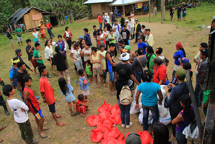 RELIEF DISTRUBUTION. Volunteers from various organizations from Monkayo, Compostela Valley and Davao City distribute 50 packs of relief goods to residents affected by the armed encounter in Barangay Rizal, Monkayo, Compostela Valley. (Earl O. Condeza/davaotoday.com)